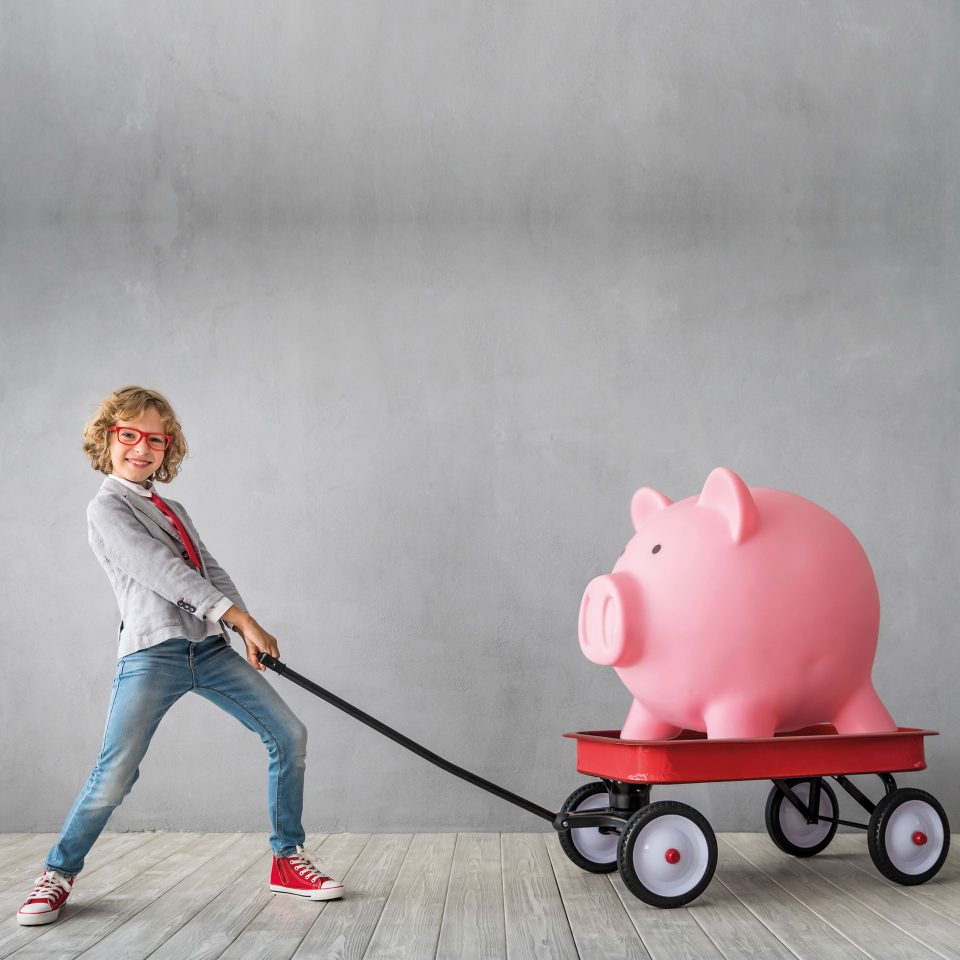 Boy pulling a piggy bank on a trailer. Cost-effective.